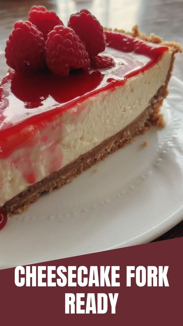 A delectable New York Cheesecake on a white plate with a spoonful removed