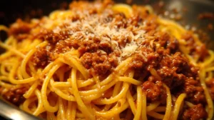 A steaming bowl of Spaghetti Bolognese garnished with fresh herbs.