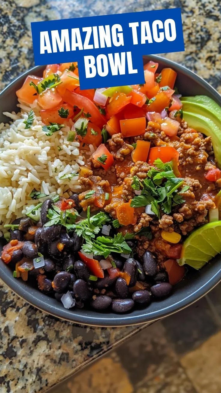 A colorful taco bowl with seasoned beef, rice, black beans, corn, avocado, and fresh salsa