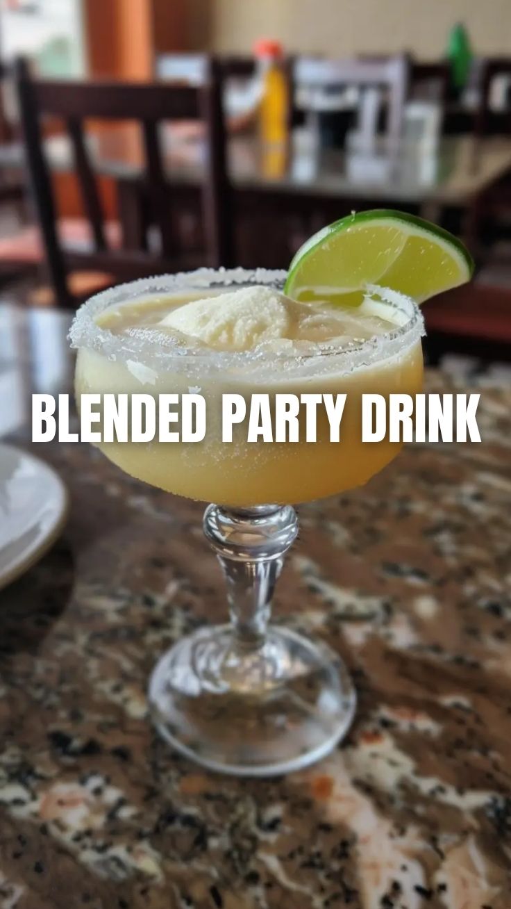 A refreshing frozen margarita in a salt-rimmed glass, garnished with a lime slice.
