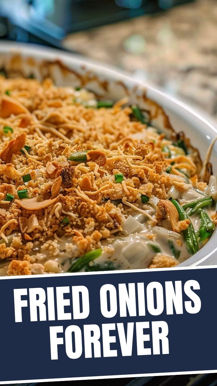 A savory green bean casserole topped with crispy fried onions on a white dish