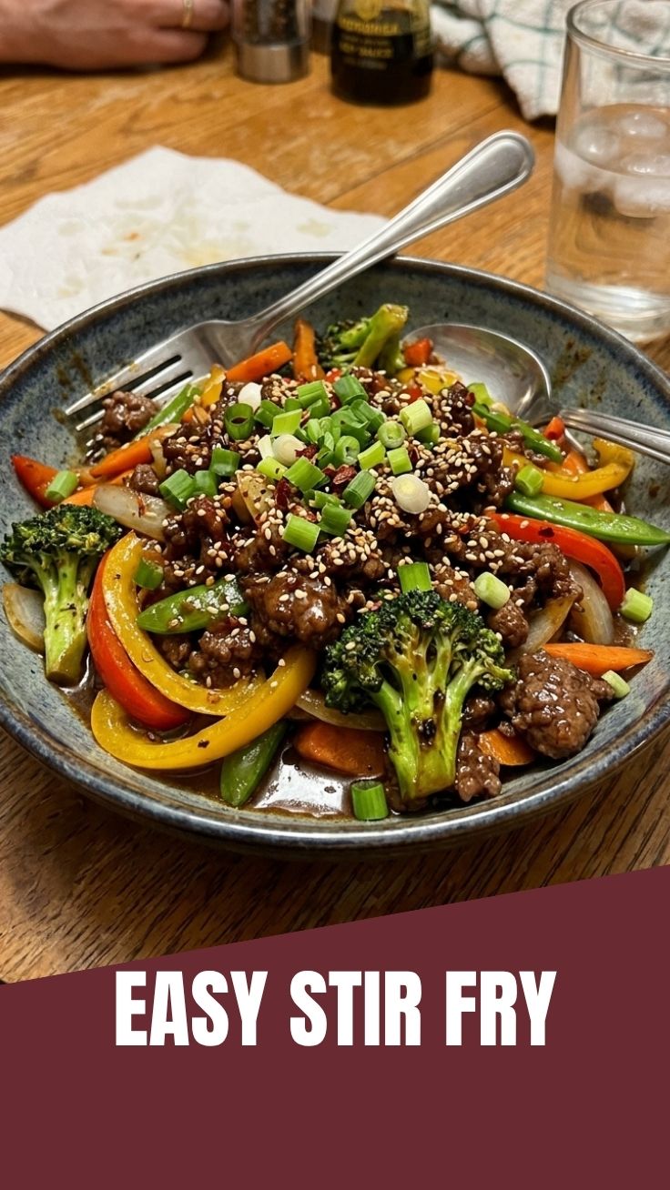 A vibrant ground beef stir fry dish in a serving bowl, garnished with fresh herbs.