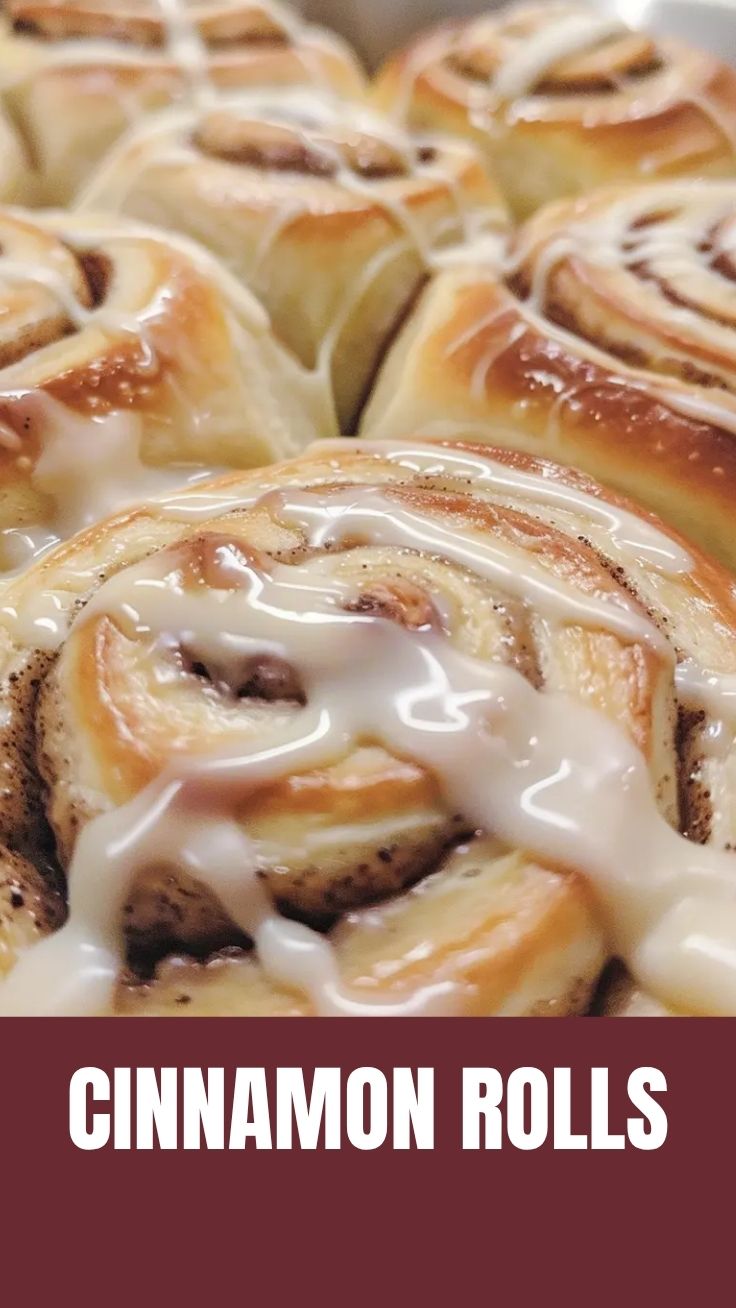 A tray of gooey homemade cinnamon rolls with white icing, fresh from the oven.