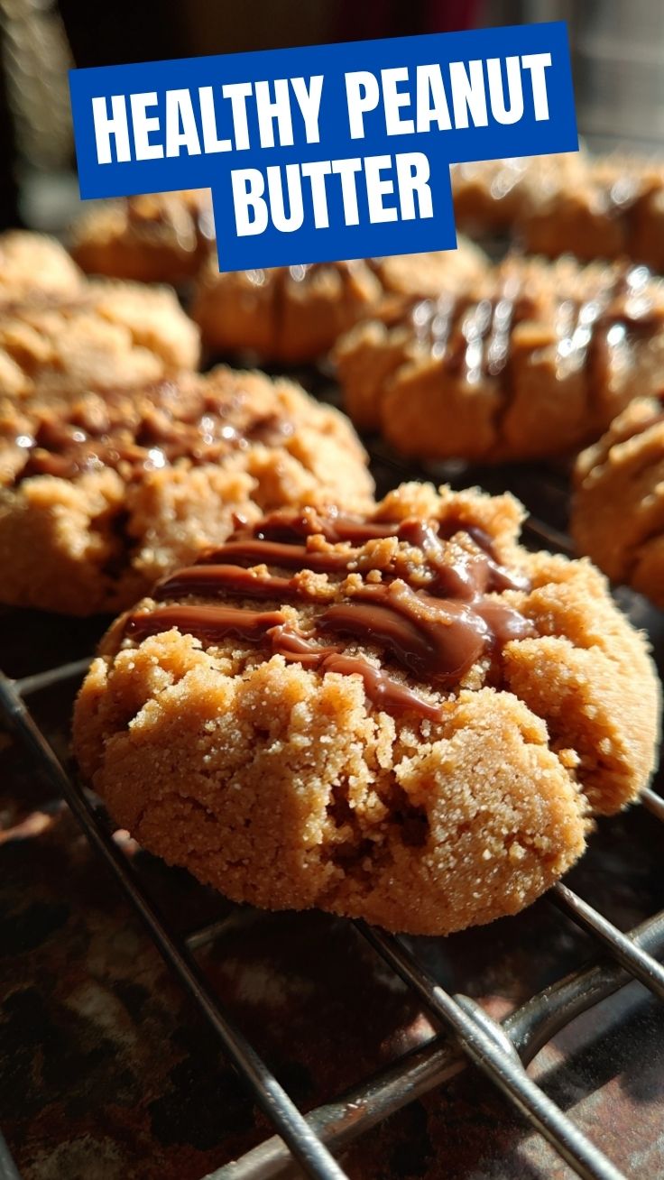 Freshly baked peanut butter cookies with fork marks on a cooling rack.