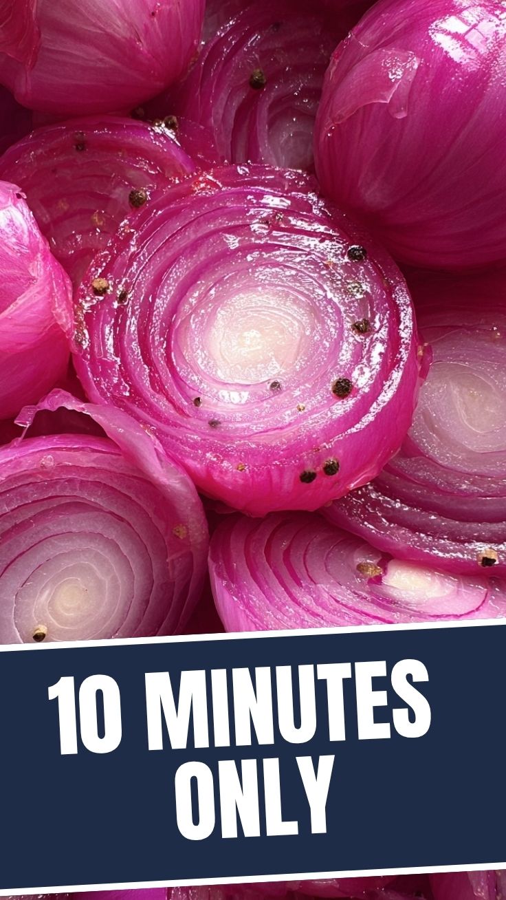 Vibrant pickled red onions in a clear glass jar.