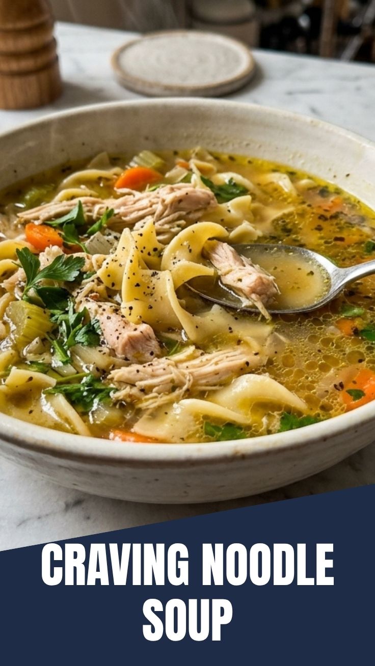 A steaming bowl of chicken noodle soup with broth, chicken, and vegetables
